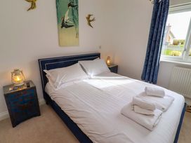 A bedroom with a bed and bedside table at Spindrifter in Beadnell