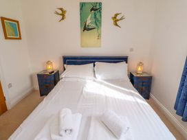 A bedroom with a bed and bedside tables at Spindrifter in Beadnell