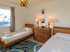 A bedroom with two beds and a dresser at Spindrifter in Beadnell