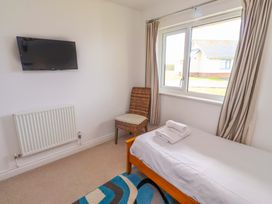 A bedroom with a single bed and television at Spindrifter in Beadnell