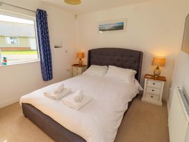 A bedroom with a bed and bedside tables at Spindrifter in Beadnell
