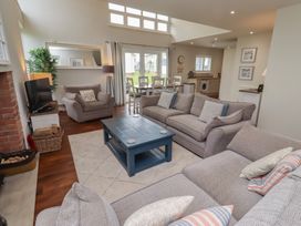 A living room with a sofa, coffee table, and armchairs at The Beach Hut in Beadnell