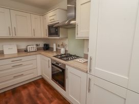 A kitchen with a gas stove and microwave at The Beach Hut in Beadnell