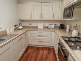 A kitchen with a sink, toaster, coffee maker and microwave at The Beach Hut in Beadnell