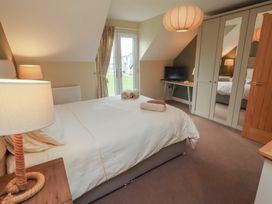 A bedroom with a bed and a television at The Beach Hut in Beadnell