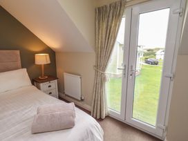 A bedroom with a bed and access to outdoor area at The Beach Hut in Beadnell