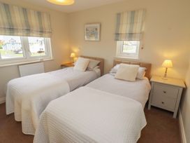 A bedroom with two single beds and bedside tables at The Beach Hut Beadnell