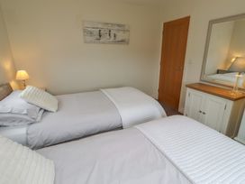 A bedroom with two single beds and a dresser at The Beach Hut in Beadnell