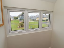 A window view showing buildings and grass at The Beach Hut in Beadnell