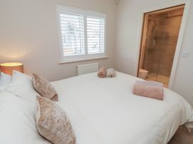 A bedroom with a double bed and an en-suite bathroom at The Beach Hut Beadnell