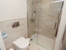 A bathroom with a shower and toilet at The Beach Hut in Beadnell