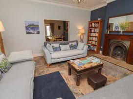 A living room with a sofa, coffee table, and bookcase at Number Seventeen Amble