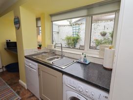 A kitchen with a sink, dishwasher, and washing machine at Number Seventeen in Amble