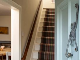 A hallway with a staircase and a decorative handle at Sandpiper (Alnmouth) in Alnmouth