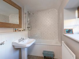 A bathroom with a bathtub and sink at Sandpiper (Alnmouth)