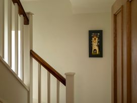 A staircase with railing and artwork on the wall at Sandpiper (Alnmouth) in Alnmouth