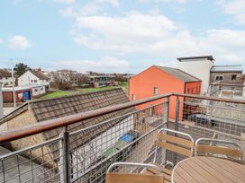 A balcony view overlooking buildings and a green space at Cuddy's Holm Seahouses