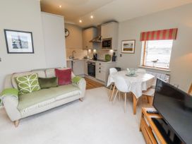 A living room with a sofa and dining area at Cuddy's Holm in Seahouses