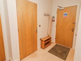 A hallway with wooden doors and coat hooks at Cuddy's Holm in Seahouses