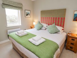 A bedroom with a double bed and bedside tables at Cuddy's Holm in Seahouses