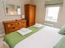 A bedroom with a bed and dresser at Cuddy's Holm Seahouses