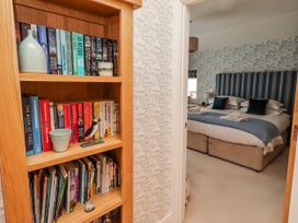 A bookshelf with books and a view of a bedroom at Cuddy's Holm Seahouses