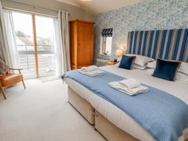 A bedroom with a bed and an armchair at Cuddy's Holm Seahouses