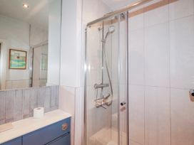 A bathroom with a shower and sink at Cuddy's Holm in Seahouses