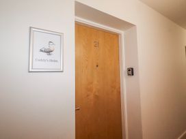 A door with number 21 and a framed picture at Cuddy's Holm in Seahouses