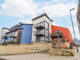 A building with balconies and a sculpture at Cuddy's Holm in Seahouses