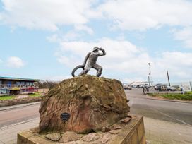 A statue on a rock near a road at Cuddy's Holm in Seahouses