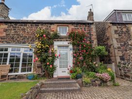 A front view of a cottage with flowers at Coble Cottage in Craster