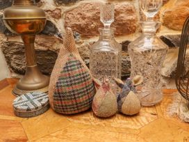 A decorative arrangement with a lamp and glass decanters at Coble Cottage in Craster