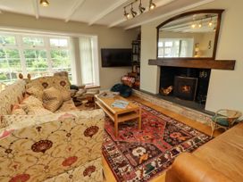 A living room with a sofa and fireplace at Coble Cottage in Craster