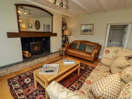 A living room with a sofa and fireplace at Coble Cottage in Craster