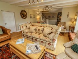 A living room with a sofa and coffee table at Coble Cottage in Craster