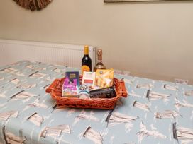 A basket with snacks and drinks on a table at Coble Cottage in Craster