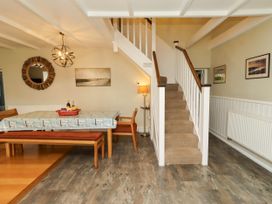 A dining room with a table and staircase at Coble Cottage Craster