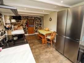 A kitchen with a table and chairs at Coble Cottage in Craster