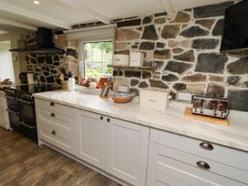 A kitchen with a stove and countertop at Coble Cottage in Craster