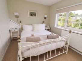 A bedroom with a double bed and nightstand at Coble Cottage in Craster