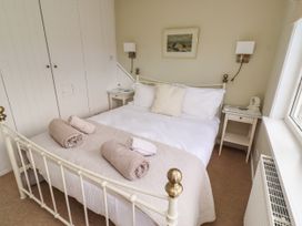 A bedroom with a bed and bedside table at Coble Cottage in Craster