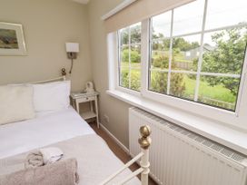 A bedroom with a bed and bedside table at Coble Cottage in Craster