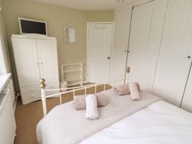 A bedroom with a bed and wardrobe at Coble Cottage in Craster