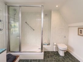 A bathroom featuring a shower and toilet at Coble Cottage in Craster