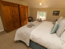 A bedroom with a bed and wardrobe at Coble Cottage Craster
