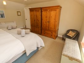 A bedroom with a bed and wooden furniture at Coble Cottage in Craster