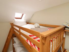 A bunk bed with pillows and blankets at Coble Cottage Craster