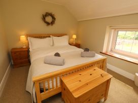 A bedroom with a bed and nightstand at Coble Cottage Craster