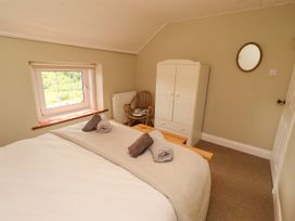 A bedroom with a bed and wardrobe at Coble Cottage in Craster